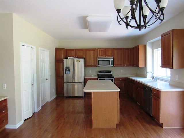 kitchen featuring stainless steel appliances, dark wood-style flooring, a sink, a chandelier, and light countertops