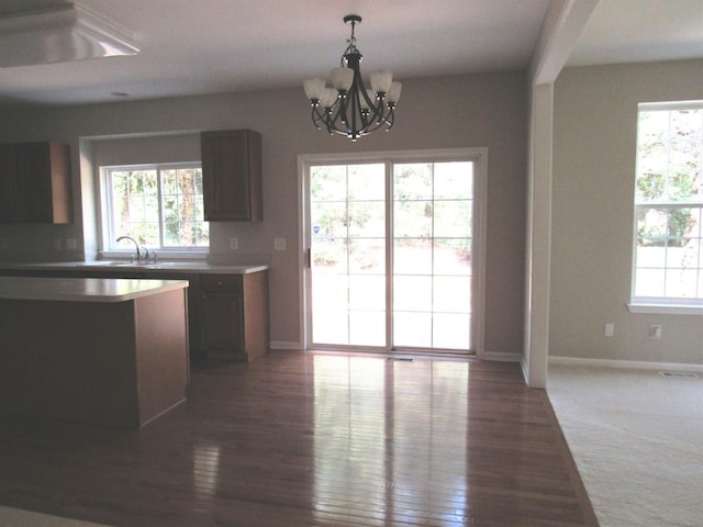kitchen with decorative light fixtures, baseboards, dark wood finished floors, visible vents, and a chandelier
