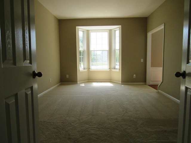 unfurnished room featuring baseboards and carpet floors
