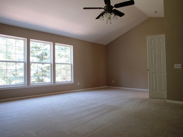 carpeted empty room with vaulted ceiling, ceiling fan, and baseboards