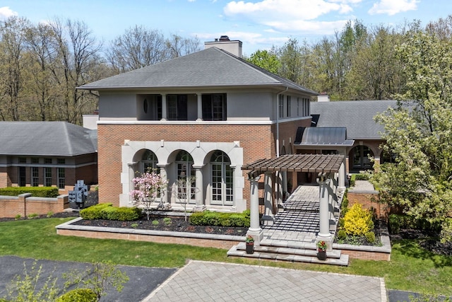 230 Corrie Rd, Ann Arbor, MI 48105 - rear view of house with a chimney, brick siding, a porch, and roof with shingles