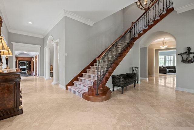 230 Corrie Rd, Ann Arbor, MI 48105 - stairway featuring arched walkways, crown molding, ornate columns, baseboards, and a towering ceiling