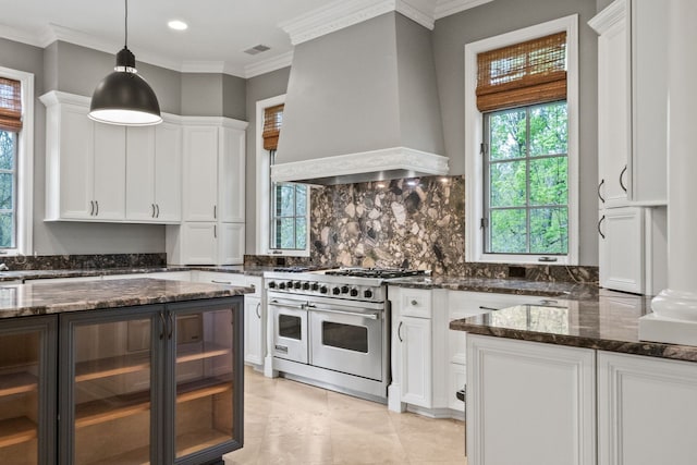 230 Corrie Rd, Ann Arbor, MI 48105 - kitchen with range with two ovens, custom range hood, white cabinets, dark stone countertops, and decorative backsplash