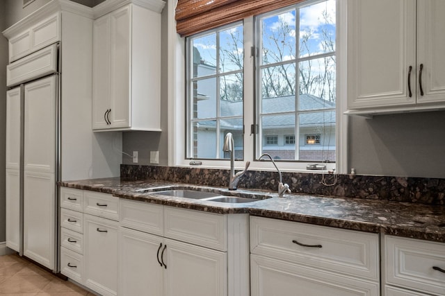 230 Corrie Rd, Ann Arbor, MI 48105 - kitchen featuring a sink, white cabinets, and dark stone countertops