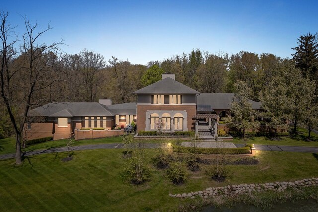 230 Corrie Rd, Ann Arbor, MI 48105 - back of property featuring a lawn and a chimney