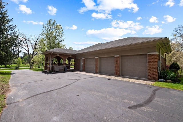 230 Corrie Rd, Ann Arbor, MI 48105 - view of front of home featuring a garage, driveway, and brick siding