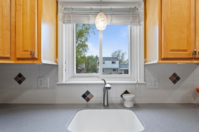 kitchen view of a sink and tasteful backsplash