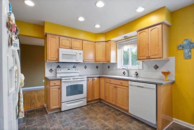 kitchen featuring white appliances, a sink, stone finish floors, backsplash, and recessed lighting