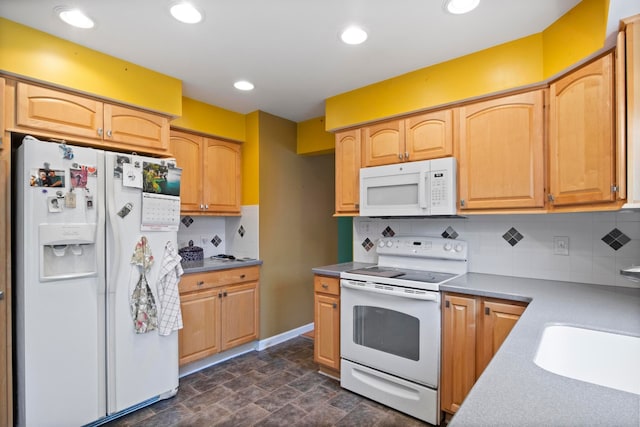 kitchen featuring white appliances, tasteful backsplash, a sink, stone finish floors, and light countertops