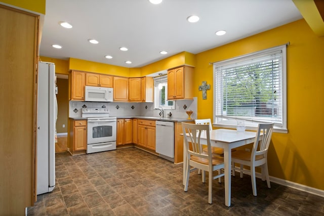 kitchen featuring white appliances, decorative backsplash, a sink, baseboards, and recessed lighting