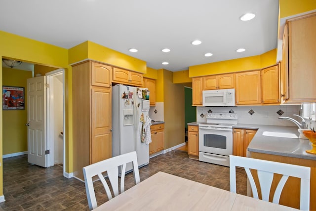 kitchen featuring white appliances, a sink, baseboards, tasteful backsplash, and recessed lighting
