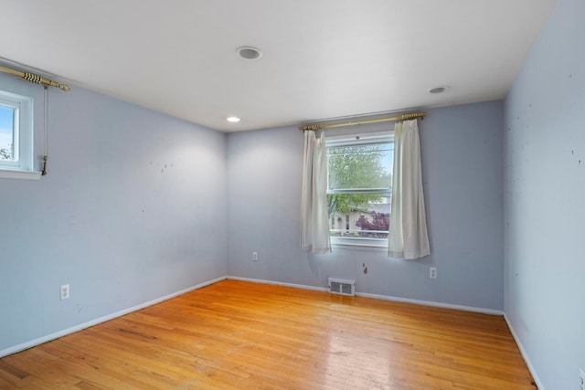 empty room featuring light wood-style floors, baseboards, and recessed lighting
