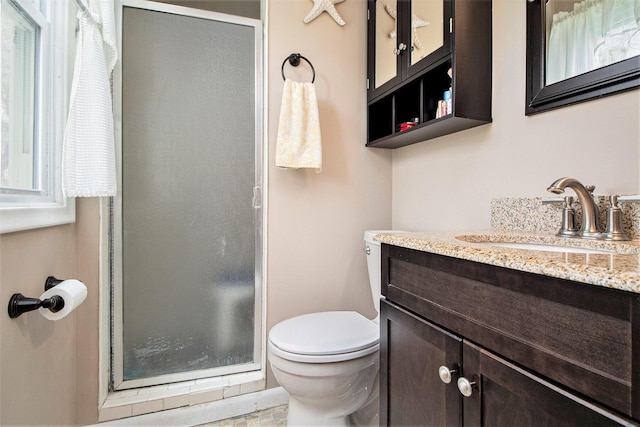 full bath featuring toilet, a shower stall, and vanity