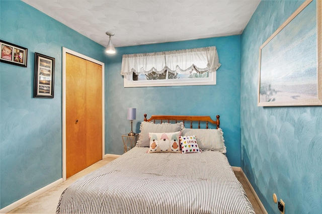 carpeted bedroom with baseboards and a closet