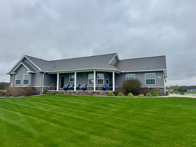 2660 Bay Pt, Imlay City, MI 48444 - view of front facade with a front lawn, covered porch, and a shingled roof