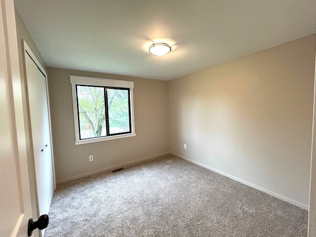 unfurnished bedroom featuring carpet floors, baseboards, and a closet