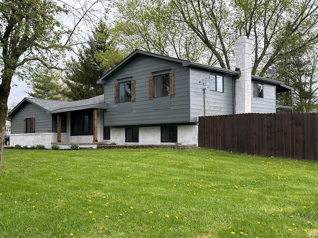 split level home featuring a chimney and brick siding