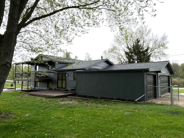 back of house with a wooden deck, a yard, and a shingled roof