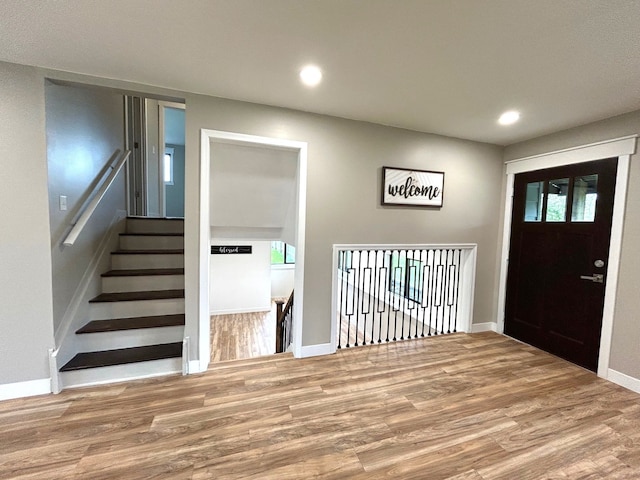 entryway featuring wood finished floors, baseboards, and recessed lighting
