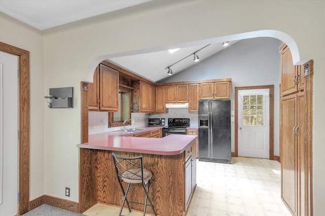 1273 Little John Lake Rd, Allegan, MI 49010 - kitchen featuring black appliances, vaulted ceiling, under cabinet range hood, arched walkways, and a sink