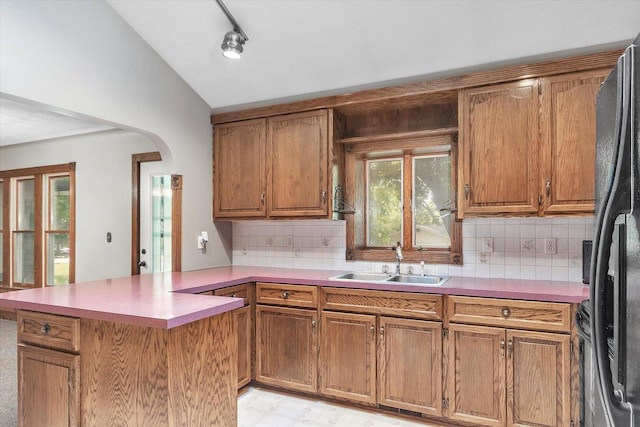1273 Little John Lake Rd, Allegan, MI 49010 - kitchen featuring a sink, a peninsula, backsplash, lofted ceiling, and black fridge