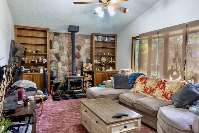 1273 Little John Lake Rd, Allegan, MI 49010 - living area featuring a wood stove, ceiling fan, vaulted ceiling, and dark carpet