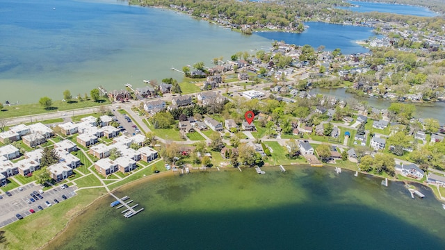 aerial view of property's location featuring a large body of water and nearby suburban area