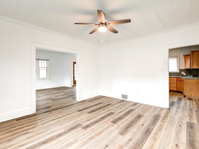 1308 10th St, Port Huron, MI 48060 - unfurnished living room featuring crown molding, light wood-style flooring, ceiling fan, plenty of natural light, and baseboards