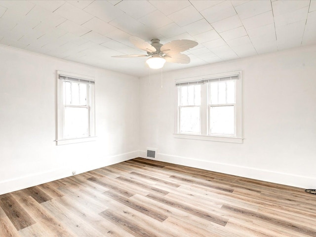 1308 10th St, Port Huron, MI 48060 - unfurnished room with plenty of natural light, ceiling fan, crown molding, wood finished floors, and baseboards