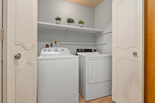 laundry room with separate washer and dryer and light wood-type flooring