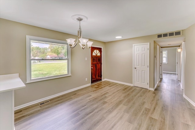 2365 Middlebelt Rd, West Bloomfield, MI 48324 - unfurnished dining area featuring a chandelier, light wood-type flooring, and baseboards