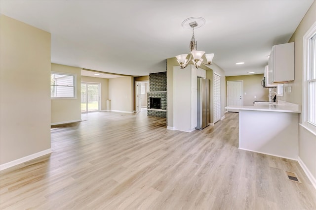 2365 Middlebelt Rd, West Bloomfield, MI 48324 - kitchen featuring freestanding refrigerator, a chandelier, open floor plan, a sink, and light countertops