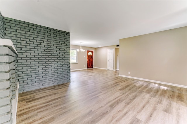 2365 Middlebelt Rd, West Bloomfield, MI 48324 - unfurnished living room with light wood-style floors, a chandelier, baseboards, and brick wall