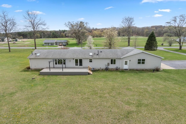 880 W Ave, Big Rapids, MI 49307 - rear view of house with a wooden deck, a yard, and view of wooded area