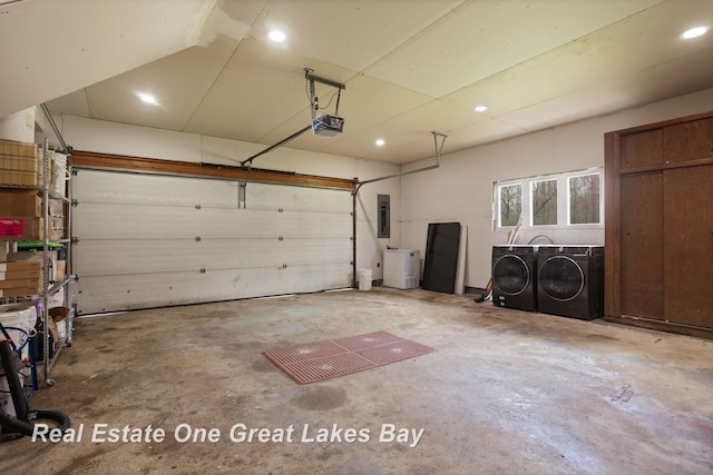 garage featuring washing machine and dryer, a garage door opener, electric panel, and recessed lighting