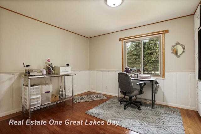 office featuring a wainscoted wall, hardwood / wood-style floors, crown molding, and a decorative wall