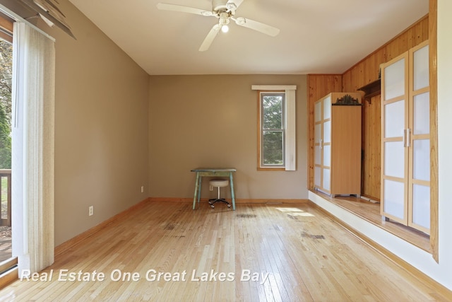 unfurnished room with hardwood / wood-style flooring, baseboards, and a ceiling fan