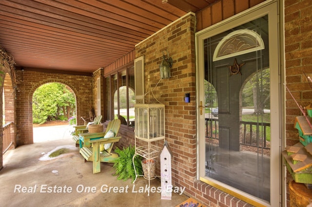 entrance to property with brick siding and covered porch
