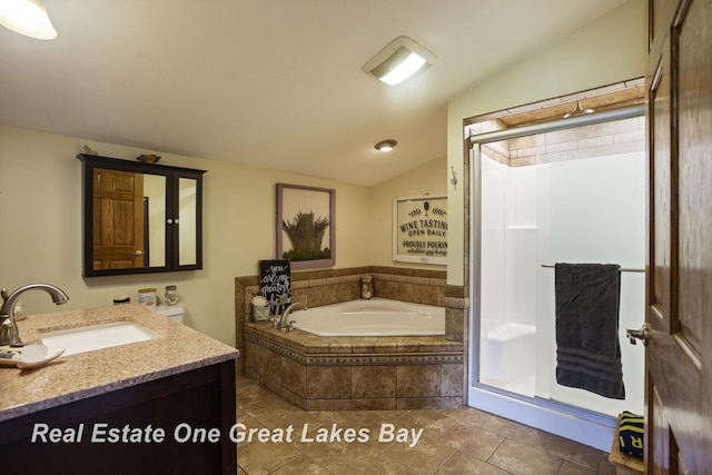 bathroom featuring vaulted ceiling, a stall shower, a garden tub, and vanity