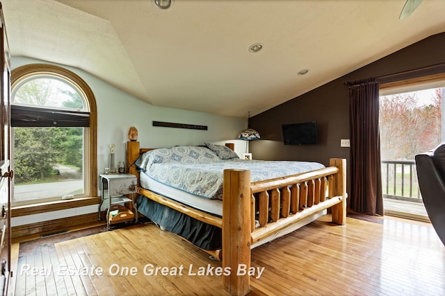 bedroom with vaulted ceiling, hardwood / wood-style floors, and access to outside