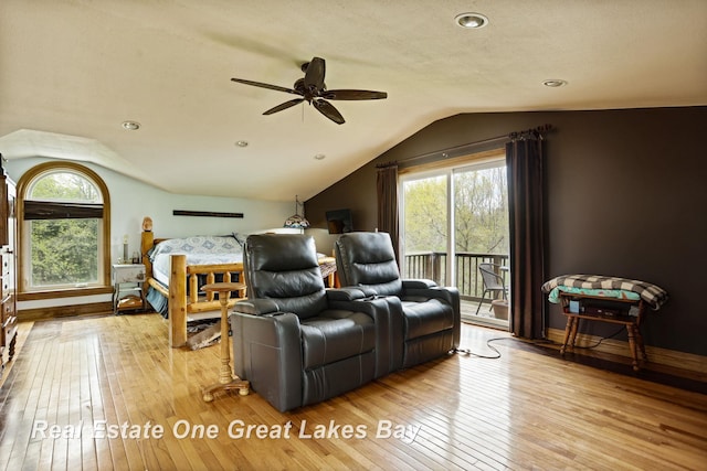 bedroom featuring vaulted ceiling, access to exterior, hardwood / wood-style floors, multiple windows, and baseboards