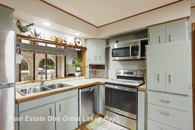 kitchen featuring appliances with stainless steel finishes, a sink, light countertops, and recessed lighting