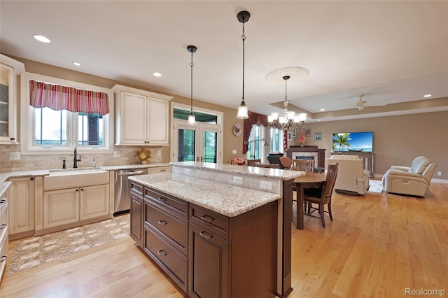 6100 30 Mile Rd, Washington, MI 48095 - kitchen featuring dishwasher, a sink, light wood-type flooring, open floor plan, and decorative backsplash