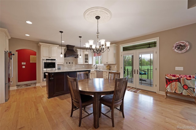 6100 30 Mile Rd, Washington, MI 48095 - dining space featuring a chandelier, baseboards, light wood-style flooring, arched walkways, and recessed lighting
