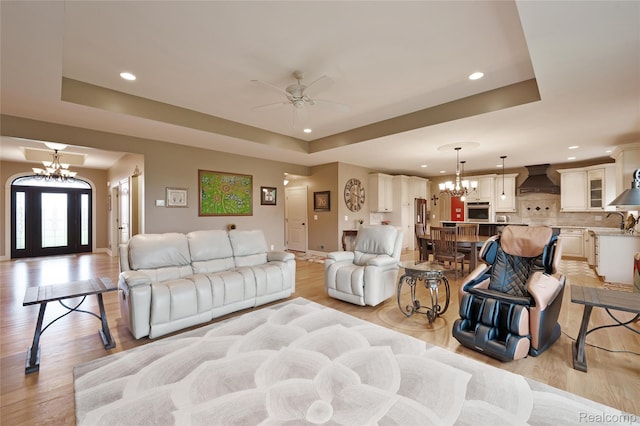 6100 30 Mile Rd, Washington, MI 48095 - living room featuring a chandelier, a tray ceiling, ceiling fan, recessed lighting, and light wood-style floors