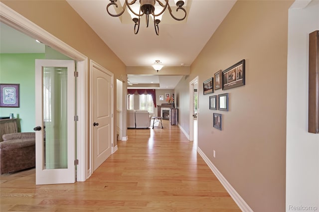 6100 30 Mile Rd, Washington, MI 48095 - corridor with light wood finished floors, a chandelier, and baseboards