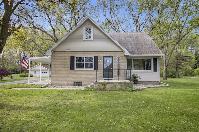 bungalow featuring brick siding, a front yard, an attached carport, and a shingled roof