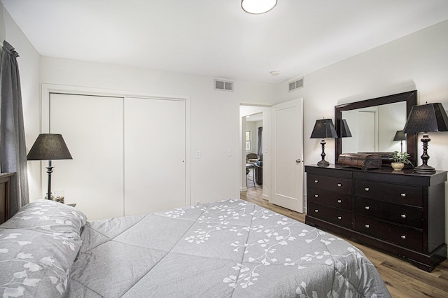 bedroom with wood finished floors and a closet