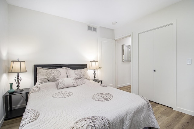 bedroom featuring wood finished floors, a closet, and baseboards