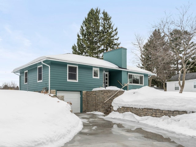 1330 N Orchard Dr, Traverse City, MI 49686 - mid-century modern home featuring a chimney, a garage, and concrete driveway